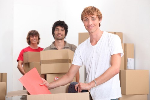 Removal team carrying office furniture through a Bow building entrance